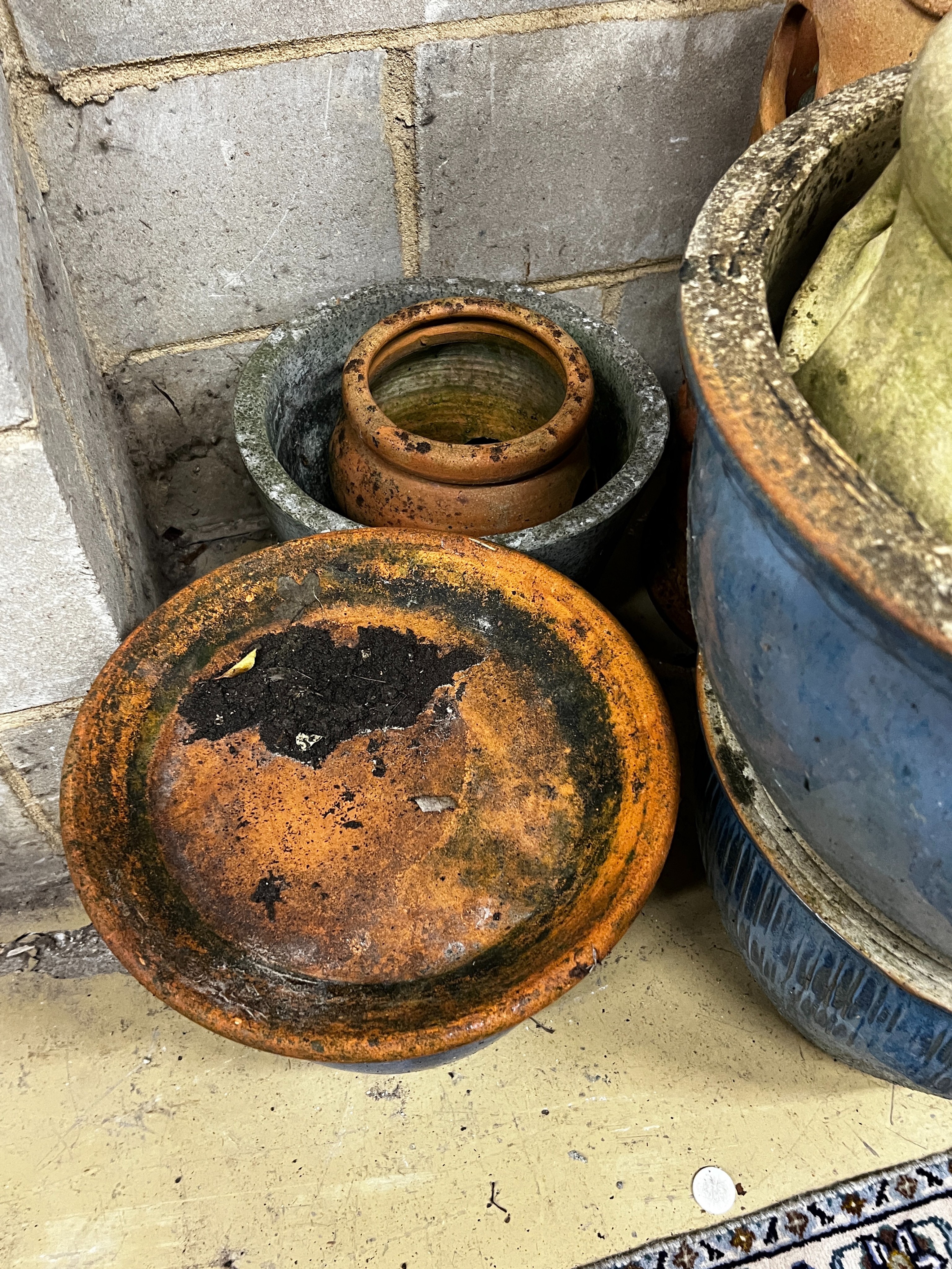 Ten assorted terracotta and glazed earthenware garden planters and three saucer bases, largest diameter 46cm, height 29cm